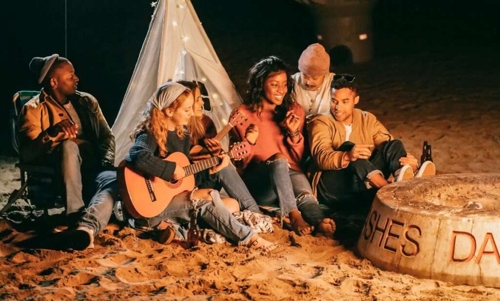 group of friends sitting on beach sand