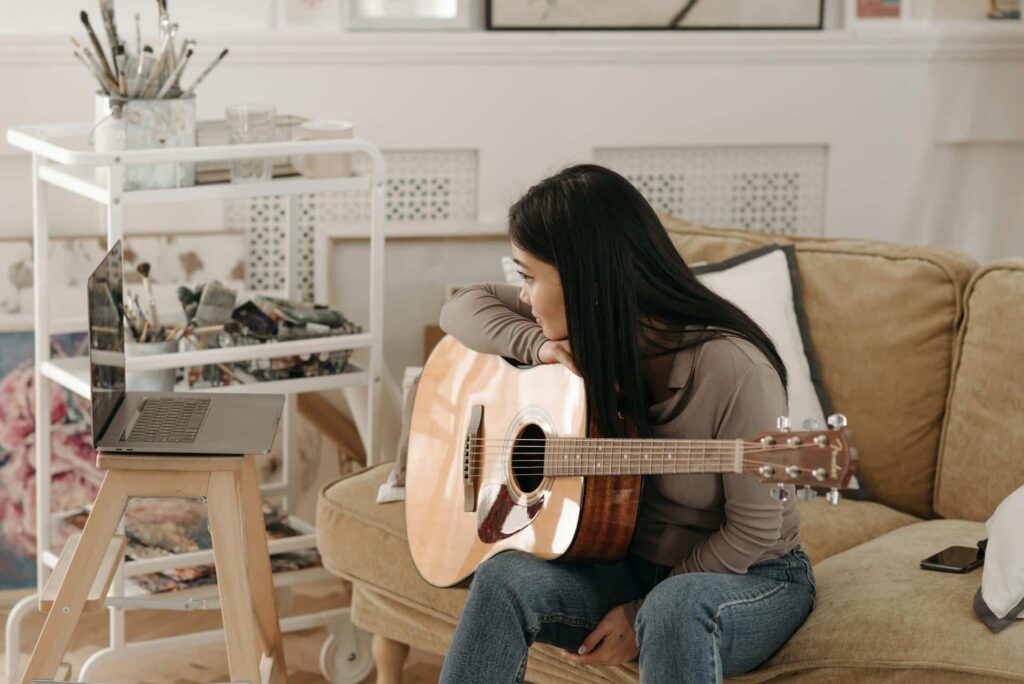 Using Video to Teach Guitar: Tips for Engaging and Effective Content. Photo by Pavel Danilyuk: https://www.pexels.com/photo/woman-learning-how-to-play-a-guitar-7120400/