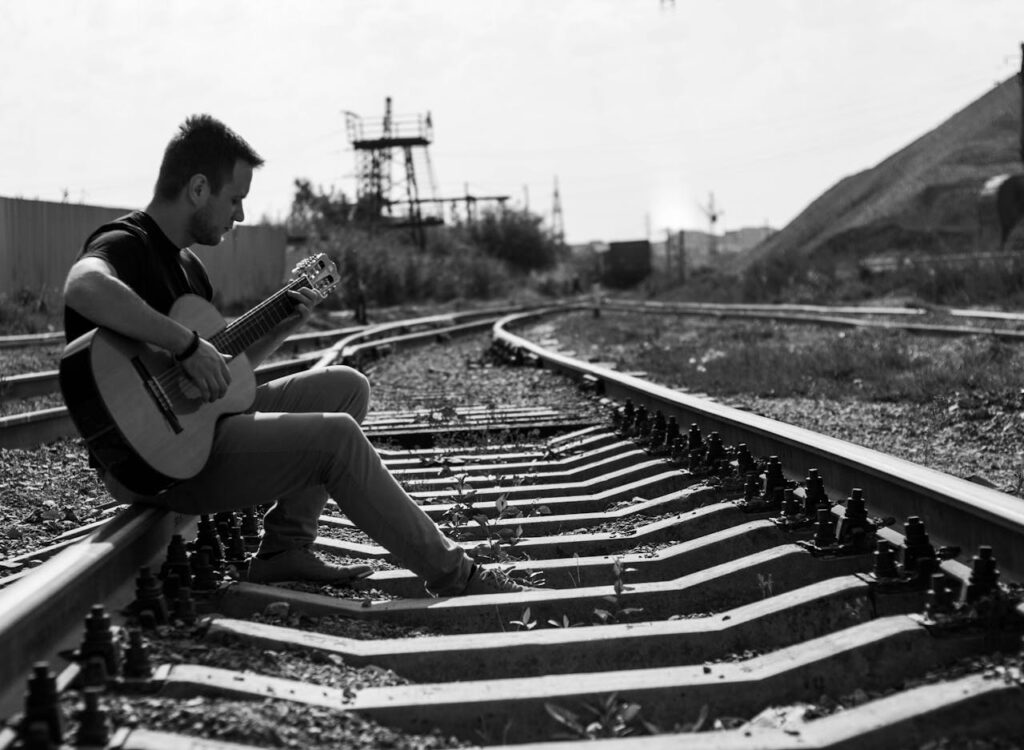 Photo by Дамир Салямов : https://www.pexels.com/photo/a-man-playing-guitar-in-the-railway-8970972/