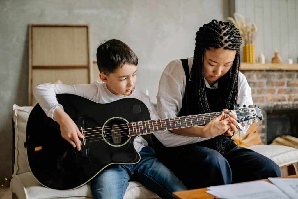 Photo by Yan Krukau: https://www.pexels.com/photo/woman-teaching-a-young-boy-how-to-play-a-guitar-8190070/